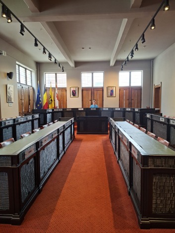 Een jongen zit in de zaal waar de gemeenteraad vergadert in het stadhuis van Dendermonde