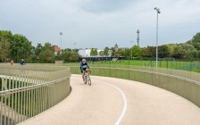 Via de fietsers- en voetgangersbrug van wijk Barakken naar Vauban stadium